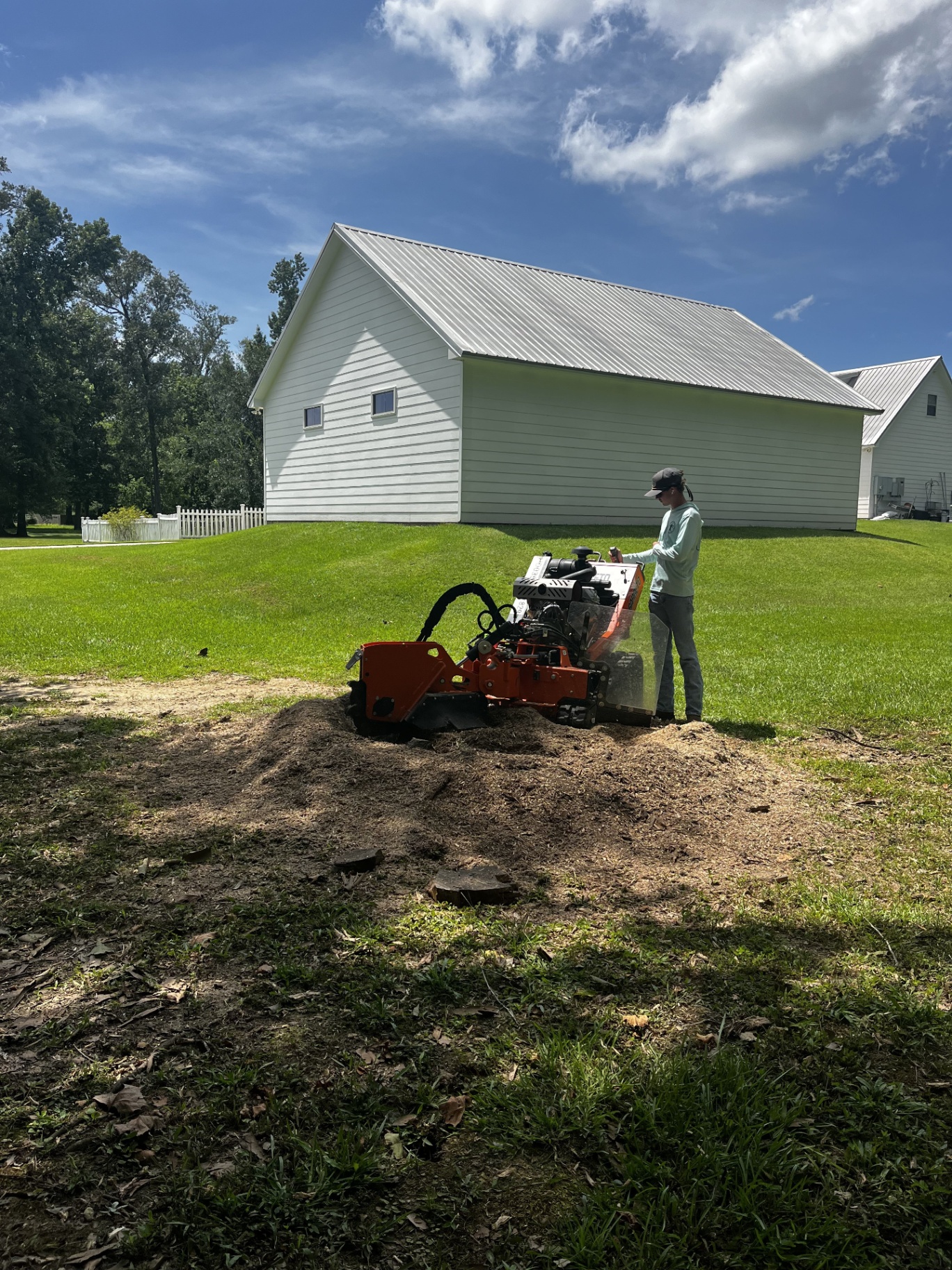 Southern Roots operator grinding a stump in a residential yard